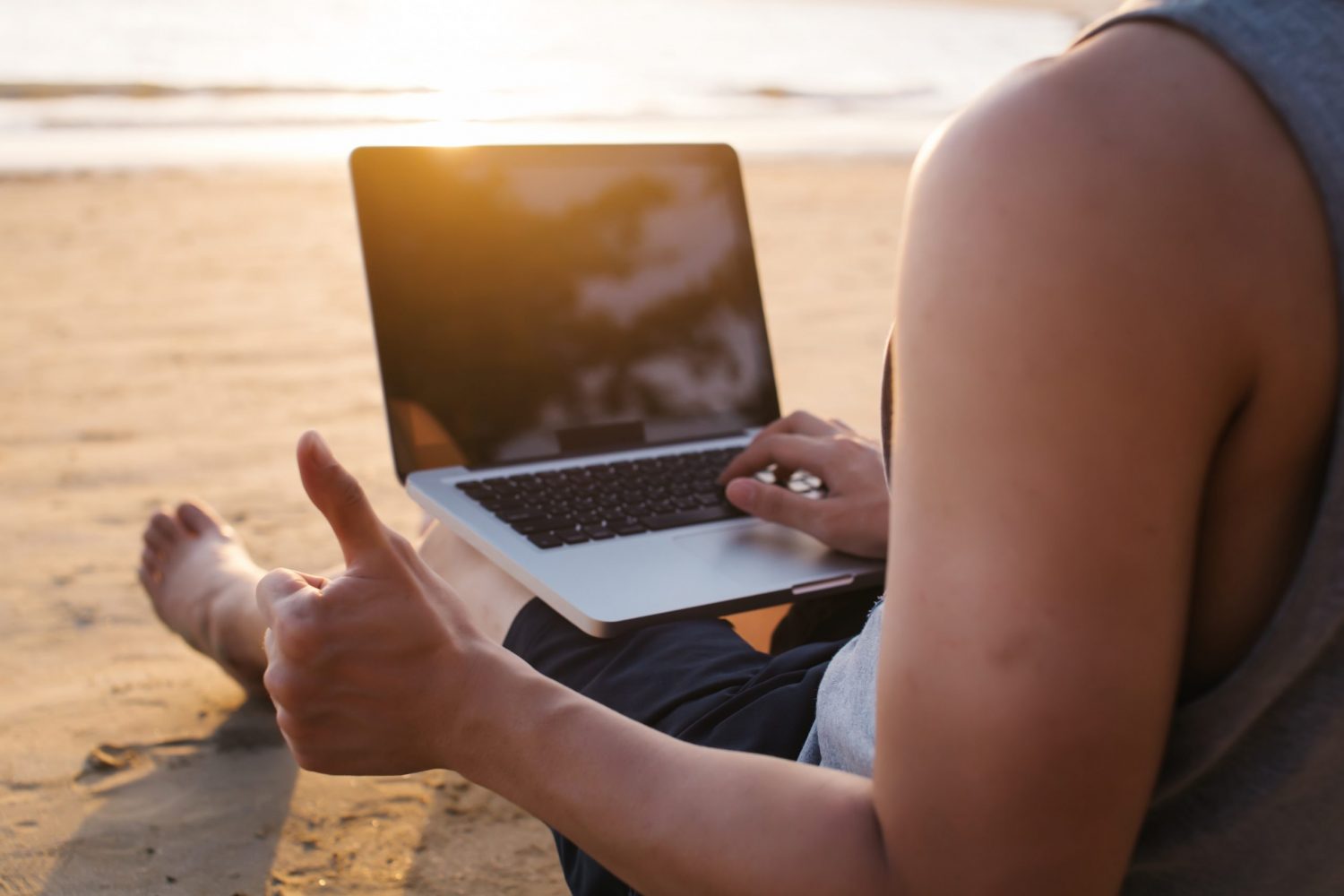 mloda kobieta siedzaca na plazy z laptopem